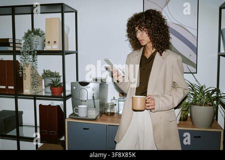Businesswoman Working in Modern Office Using Smartphone Stock Photo