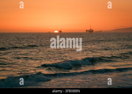 Waves in the Pacific Ocean at sunset in Huntington Beach, Orange County, California Stock Photo