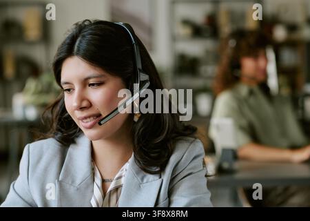 Hispanic Woman Wearing Headset Talking to Client in Call Center Stock Photo