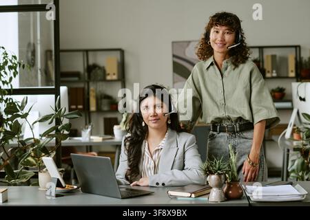 Portrait of Diverse Female Helpdesk Team Smiling at Camera Stock Photo