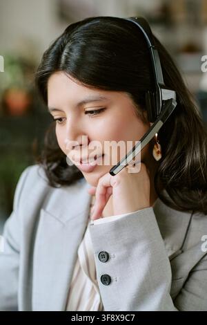 Hispanic Woman Working in Call Center Wearing Headset Stock Photo
