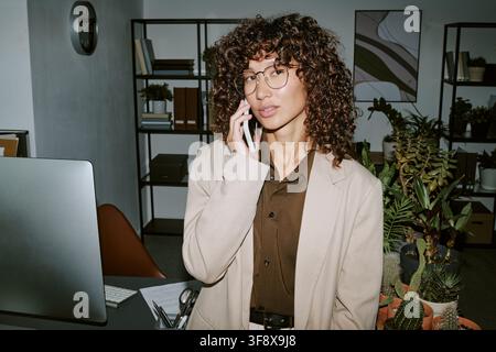 Businesswoman Having Phone Call in Modern Office Stock Photo