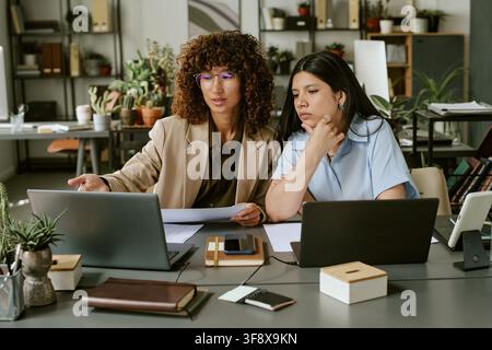 Diverse Women Colleagues Working on Laptop in Modern Office Stock Photo