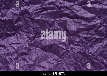 Crumpled Purple Paper Texture With Deep Wrinkles Folds And Creases Filling Frame Macro Surface Background For Wrapping Or Craft Material Styling And Detail Studies. Stock Photo
