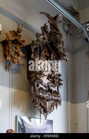 Eschach, Germany 27 Jul 25: Decorative carved wooden cuckoo clocks with wildlife motifs hang on a wall inside the Seifertshofen technology museum in B Stock Photo
