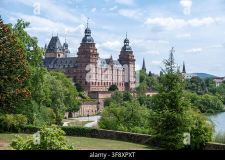 Exterior view from the Pompejanum gardens toward Johannisburg Palace across trees and the Main River in Aschaffenburg, Germany. Stock Photo