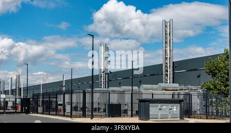 AWS Cloud Data Centre Facility, Belgard Road, Tallaght, Dublin. Modern industrial building with security fencing, exhaust stacks, and street lamps. Stock Photo