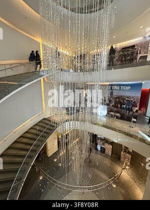 A glamorous atrium at Rockefeller Center, Manhattan, featuring an intricate ceiling chandelier and modern staircase. Stock Photo