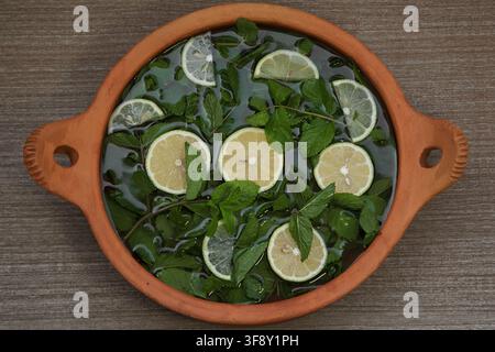 sliced lemon and ginger root with mint sprigs on a dark background Stock Photo