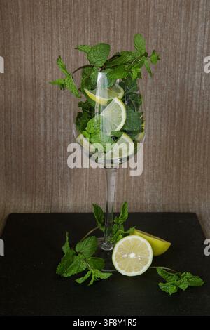 sliced lemon and ginger root with mint sprigs on a dark background Stock Photo