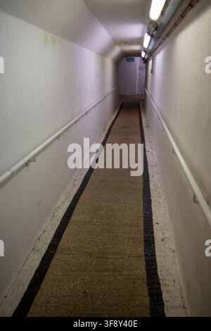 Long white corridor with handrails and overhead lighting inside the historic Spike Island fortress and former prison in Ireland. Stock Photo