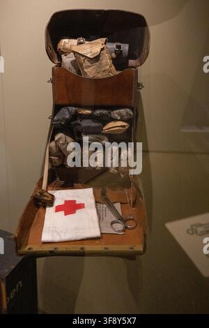 Bastone, Belgium - 21 Jul 25: Open leather medical bag with bandages, Red Cross cloth, scissors, and field supplies displayed in Bastogne, Belgium. Stock Photo