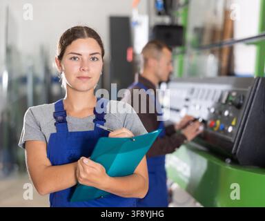Portrait of foreman girl with folder of documents in glass workshop Stock Photo