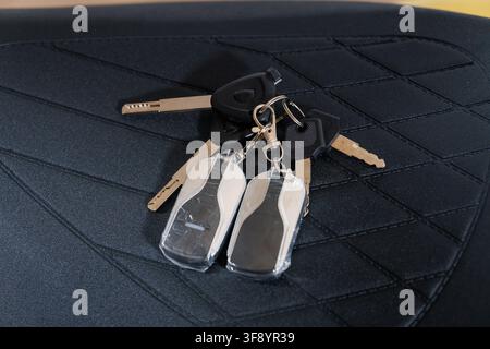 Close up of vehicle security keys on a luxury leather background for automotive and real estate themes Stock Photo