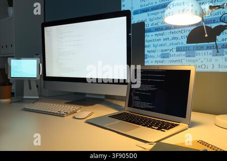 Developers desk with multiple screens displaying code, programming and software development concept, modern technology workspace Stock Photo