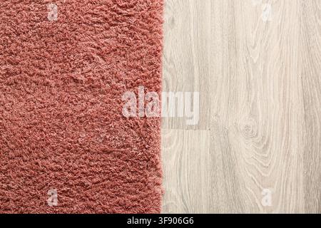 Shaggy pink carpet texture next to light wood laminate flooring, home interior design and renovation Stock Photo