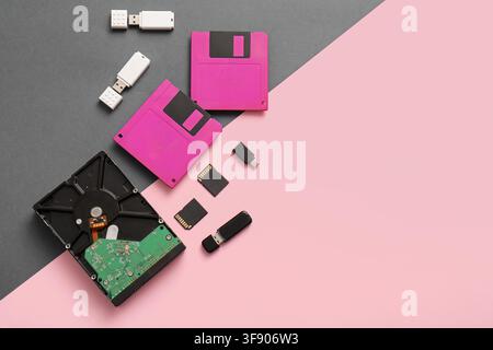 Evolution of data storage devices with floppy disks, hard drive, flash drives, and memory cards on a split background Stock Photo