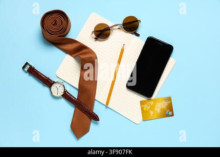 Stylish mens accessories with modern mobile phone and notebook on blue background Stock Photo