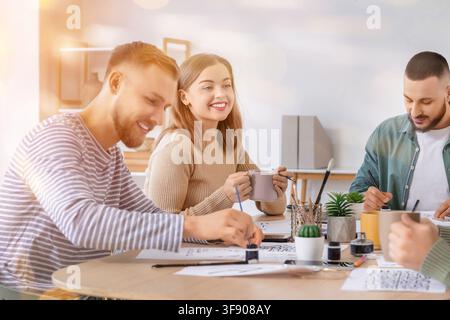 Young adults learning calligraphy and drawing together in a bright art class or workshop setting, Young adults engage in a calligraphy and drawing cla Stock Photo