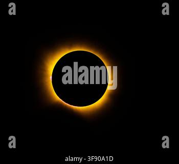 Solar eclipse glows against black sky. Crimson sunburst radiates around dark moon. Nature's cosmic spectacle, serene and powerful. Perfect for science Stock Photo