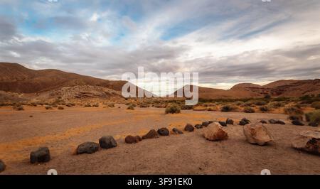 High desert valley and rugged mountain terrain beneath dramatic storm clouds in California. Stock Photo