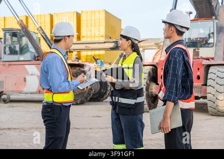Construction team collaborating on project details at the job site for enhanced safety compliance. Ideal for business, teamwork, management, and const Stock Photo