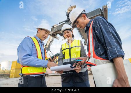 Construction team members discussing plans at a job site to ensure project safety and compliance. Ideal for business, architecture, construction, team Stock Photo
