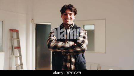 Arms crossed, construction and project management with architect man in home for building renovation. Creative, interior design and portrait of happy Stock Photo