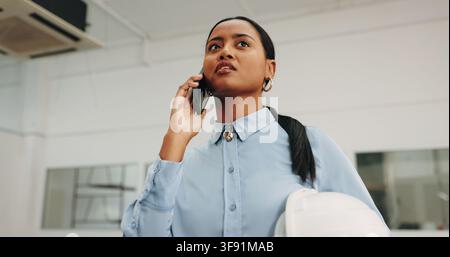 Phone call, talking and architect with woman on site for building inspection, renovation and contact. Construction, engineer and real estate update Stock Photo