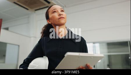 Woman, architect or thinking with checklist in building for security, maintenance or safety. Female person, contractor or civil engineer checking Stock Photo