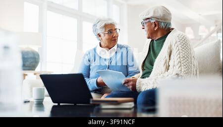 Senior, couple and documents with laptop in home for financial planning, tax or asset management. Elderly, man and woman with paper or computer for Stock Photo
