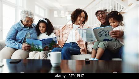 Grandparents, big family and reading book in home with kids, smile or learning with mother. Bonding, happy children or generations with literature on Stock Photo