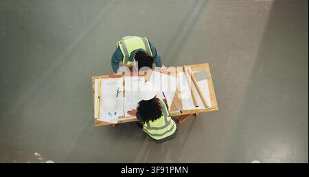 Architect, people or planning with blueprint for construction strategy, ideas or discussion. Top view, man and woman with documents or floor layout Stock Photo