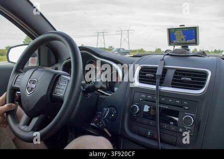 Driver using a GPS navigation device inside a Dodge car in the Caribbean. Stock Photo