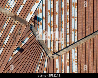 Aerial view of weathered metal rooftop patterns with rusted corrugated sheets and white painted stripes in Belgrade, Serbia. Stock Photo