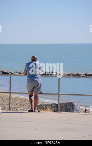 a black man looking out to sea on a hot summers day uk Stock Photo