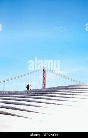 Couple walking together up steps under blue sky Stock Photo
