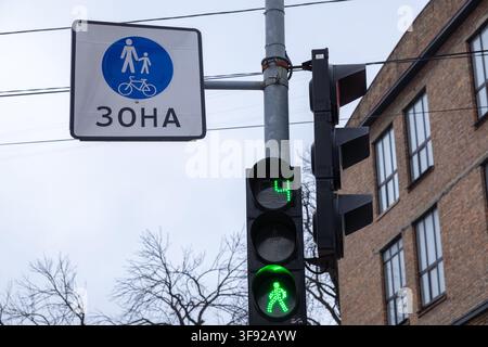 The illuminated green walk signal and digital timer help people cross the street safely within a city environment that integrates pedestrian infrastru Stock Photo