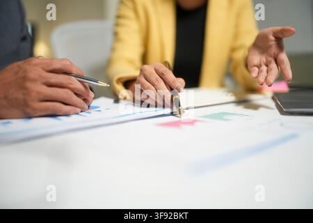 Business team reviewing charts in meeting Stock Photo