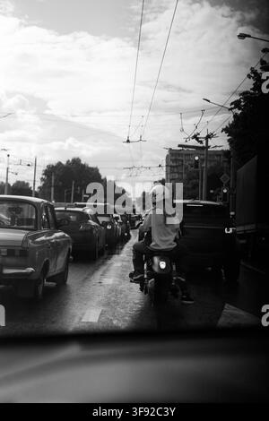 Two people on a motorcycle waiting in heavy city traffic Stock Photo
