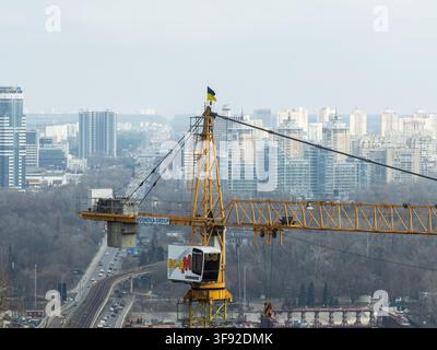 Kyiv, Ukraine - March 21, 2026: A Liebherr construction crane rises over a sprawling metropolitan area, capturing industrial growth and infrastructure Stock Photo