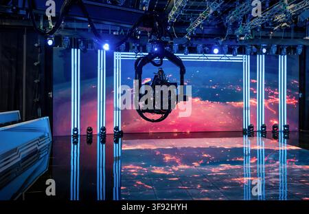 Professional video camera on crane in modern TV studio. Wide shot of a professional video camera on a motorized robotic jib suspended in a TV studio. Stock Photo