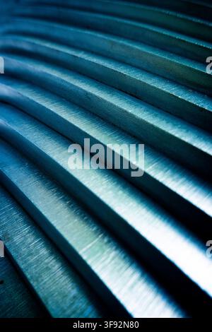 close-up of blue-toned metal bars with brushed surfaces, repeating parallel ridges and strong diagonal perspective Stock Photo