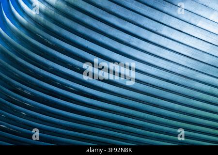 close-up of blue-toned metal bars with brushed surfaces, repeating parallel ridges and strong diagonal perspective Stock Photo