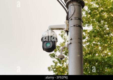 An outdoor surveillance camera mounted on a utility pole, illustrating professional security monitoring, urban infrastructure, and public safety Stock Photo