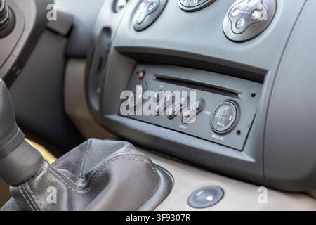 Close view of an integrated car audio system with numerical buttons and a shift knob, conveying modern vehicle utility and the essential mechanics of Stock Photo