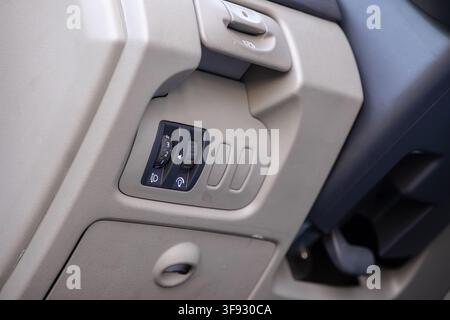 An adjustable headlight level wheel and panel brightness buttons integrated into a car dashboard, highlighting the functional design of vehicle contro Stock Photo
