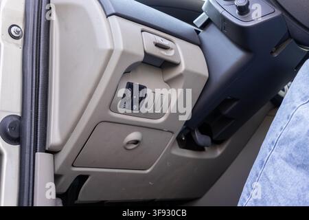 Close view of car interior light toggle switches and manual adjustment dial on the side console, reflecting vehicle ergonomics and standard equipment Stock Photo