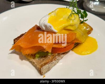 Eggs Benedict, Frühstücksgericht aus der Küche der USA, aus pochierten Eiern auf Toast oder halbierten englischen Muffins mit einer Scheibe angebratenem Kochschinken oder Frühstücksspeck hier mit Lachs und Sauce Hollandaise. 14.08.2026 *** Eggs Benedict, a breakfast dish from the United States, made with poached eggs on toast or halved English muffins, topped with a slice of pan-fried ham or breakfast bacon here served with salmon and hollandaise sauce 08/14/2026 Stock Photo