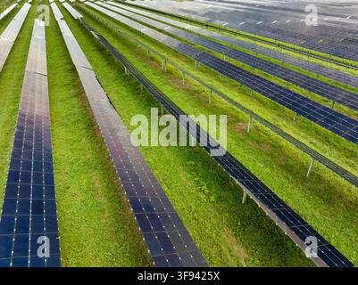 View from above of photovoltaic power plant with many rows of solar panels for producing clean electrical energy. Concept of renewable electricity wit Stock Photo